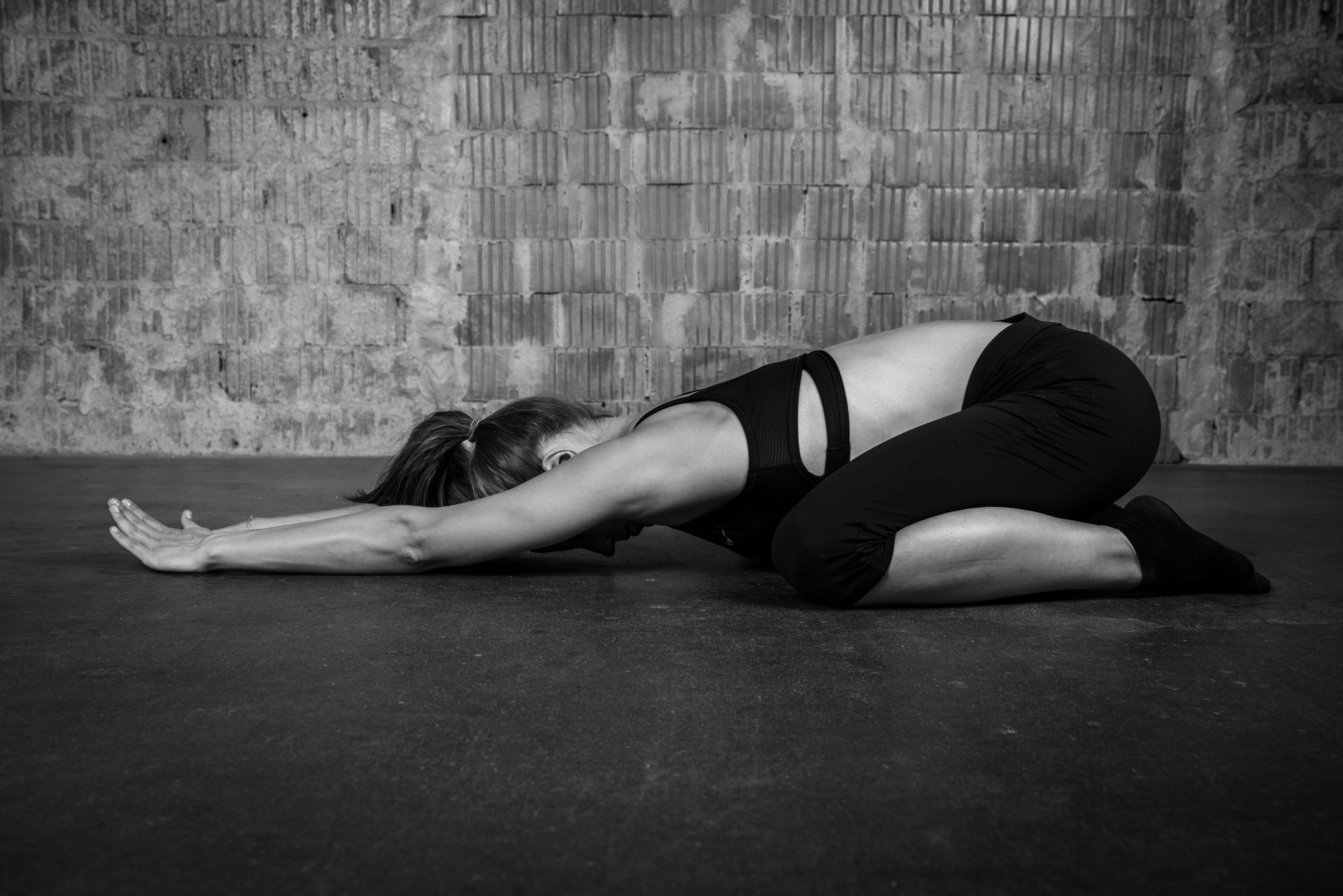 Caucasian blonde yoga woman practicing sport pose extended puppy monochrome